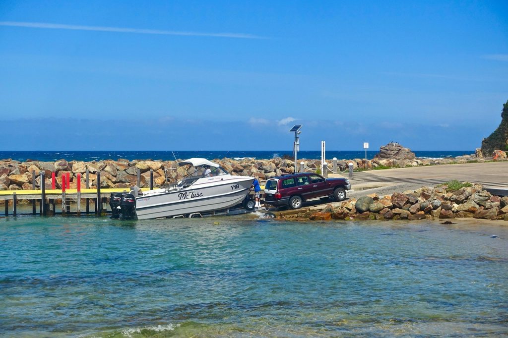 Solo boater securing a bow line to a dock cleat after launching a fishing boat